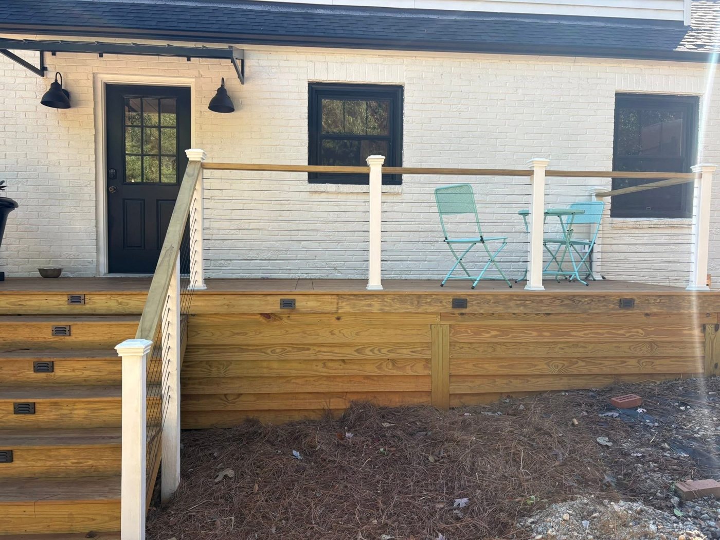Finished deck with cable railing and lighted stairs by Omni Home