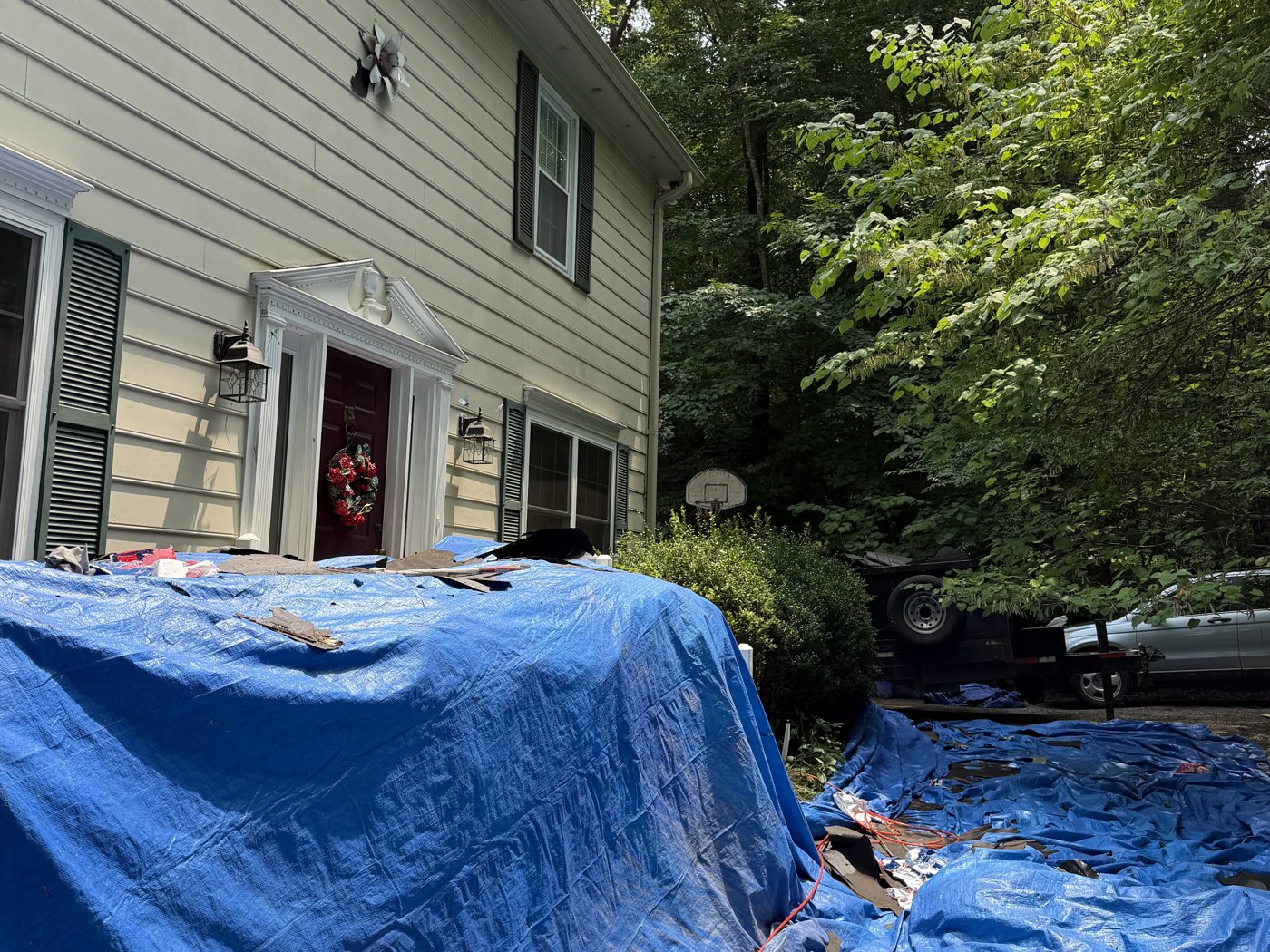 Tarps protecting the yard and landscaping during a roof replacement